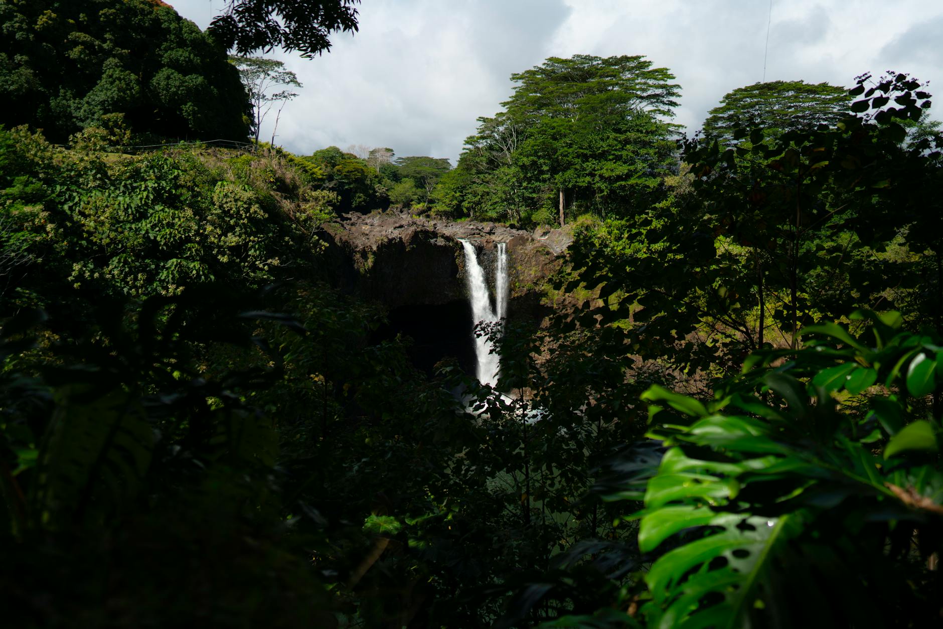 Waterfall cascading through Dominica's lush tropical rainforest