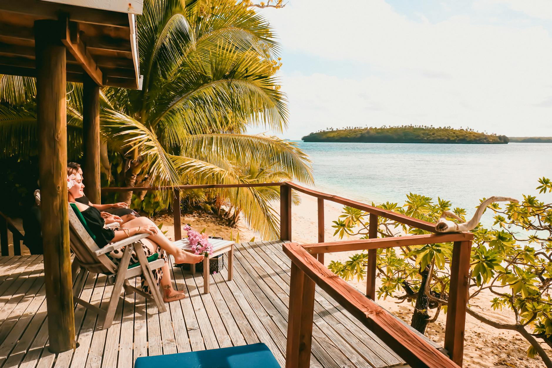 Tropical beach view from a wooden deck overlooking a calm Tongan shore