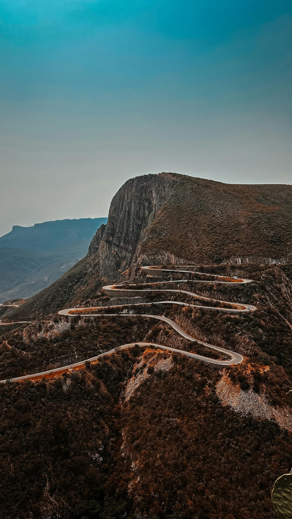 Aerial view of a winding mountain road cutting through the arid hills of Namibe Province, southern Angola