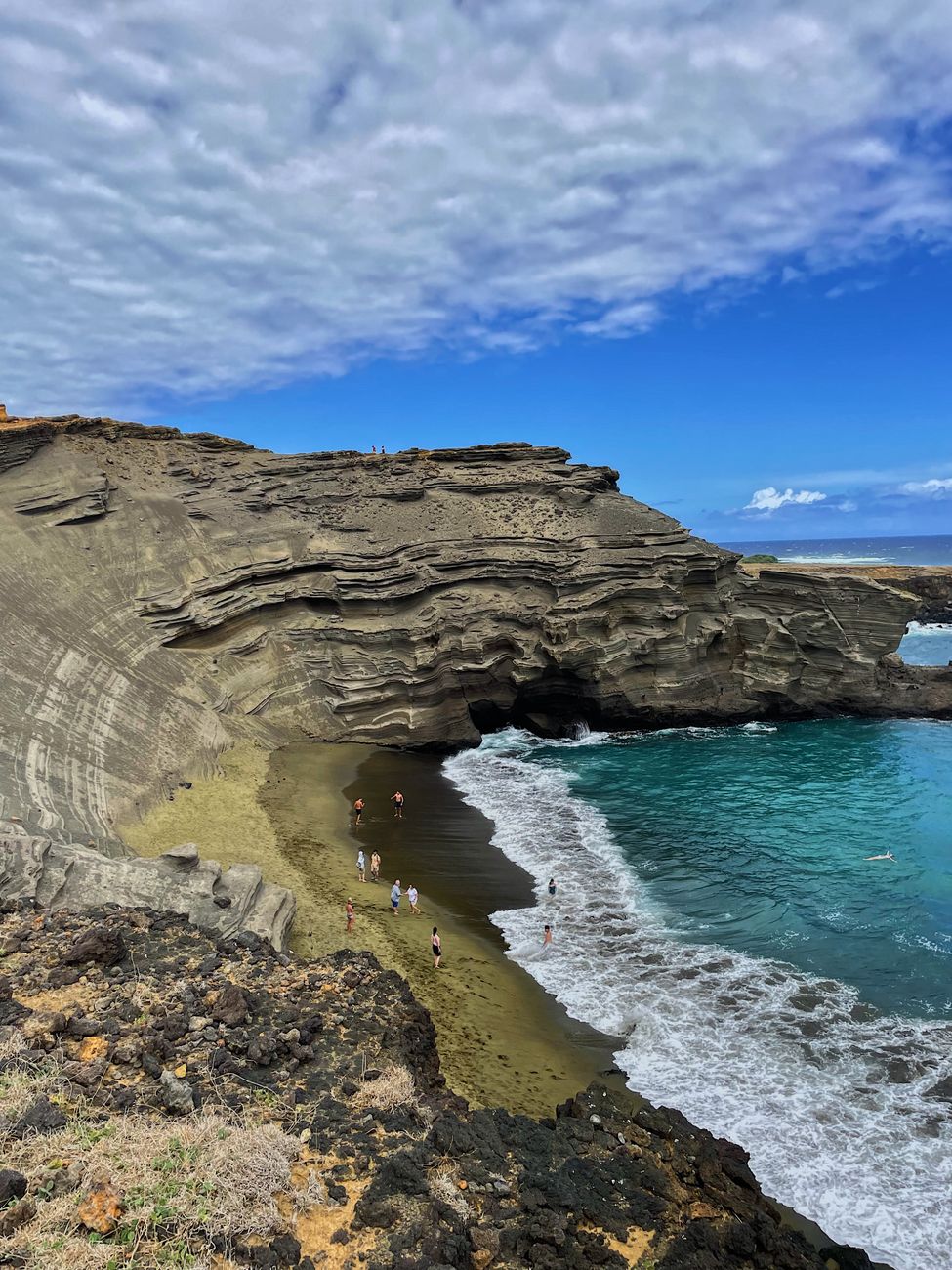 Olive-green sand and blue water at Papakōlea green sand beach