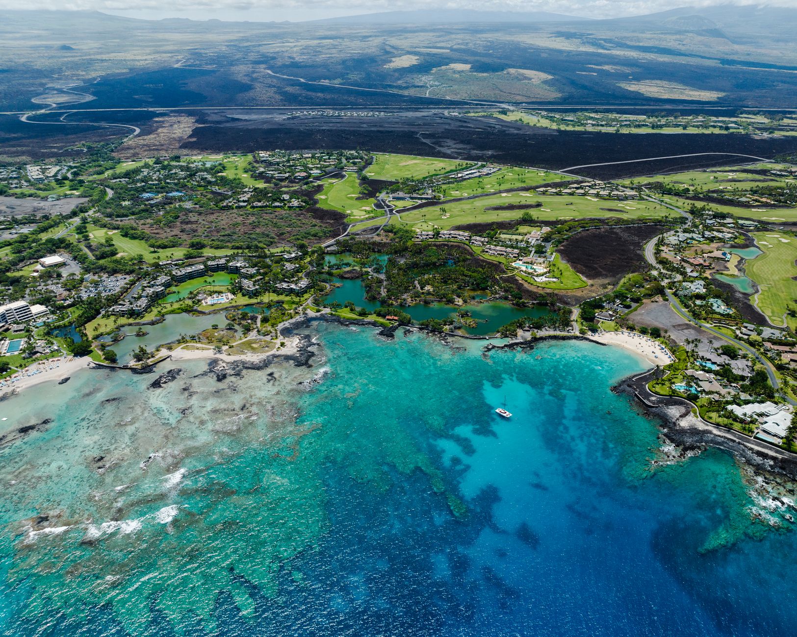 Black lava coastline meeting turquoise ocean on the Big Island of Hawaiʻi