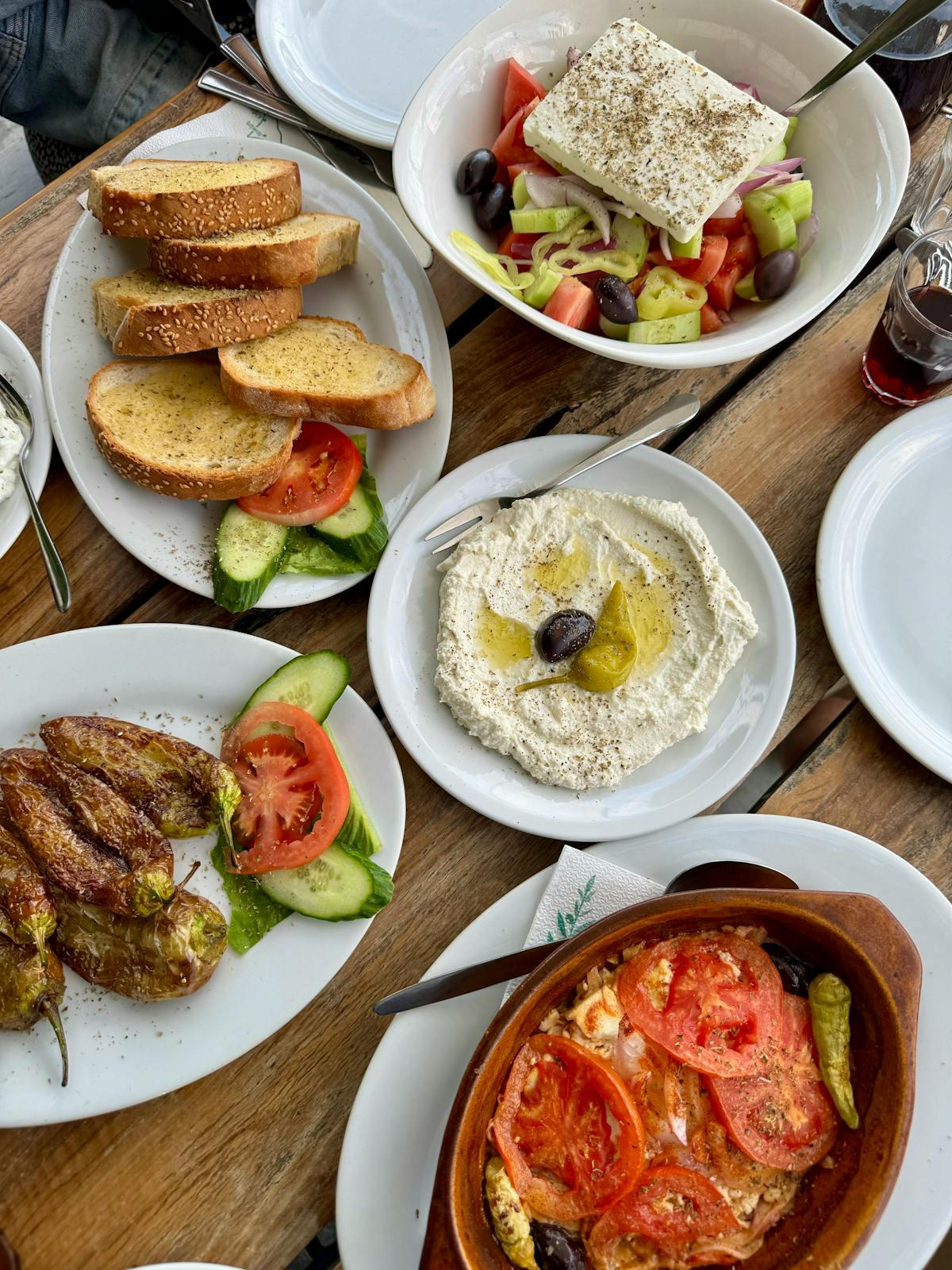 Mediterranean meze, salad and bread on a rustic wooden table