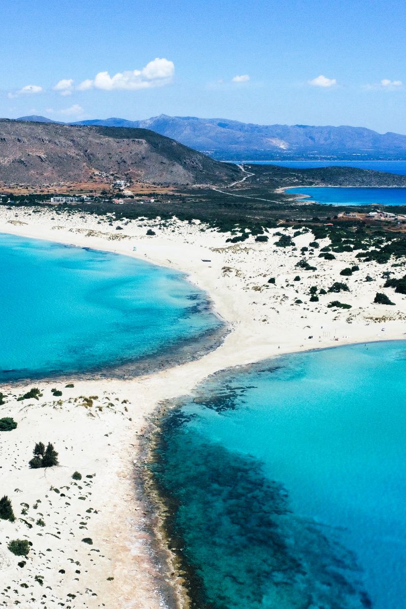 Pink-tinged sand and shallow turquoise lagoon at Elafonissi beach, Crete
