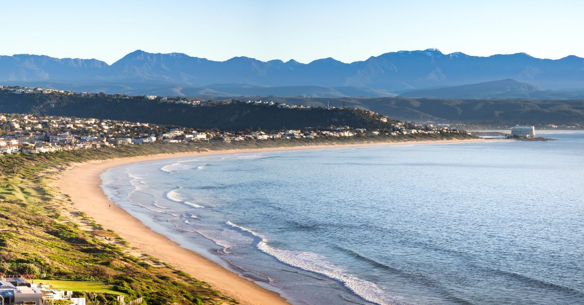 Aerial view of Plettenberg Bay's coastline with mountains rising behind the beaches on the Garden Route