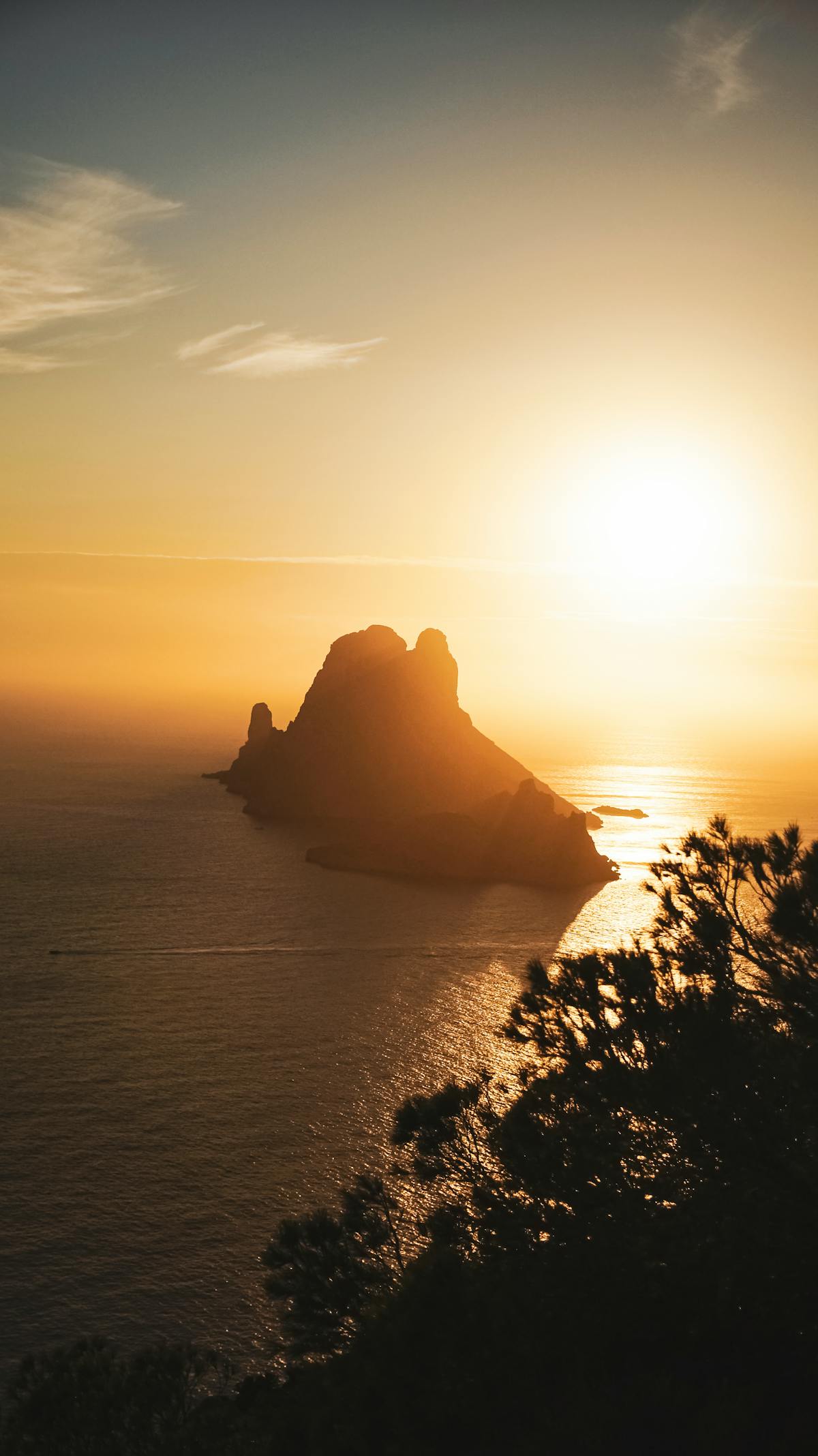 The limestone islet of Es Vedrà rising offshore at sunset on Ibiza's south-west coast