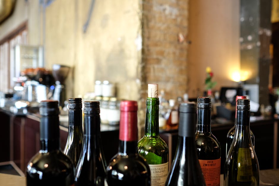Wine bottles and glasses arranged on a wooden bar counter