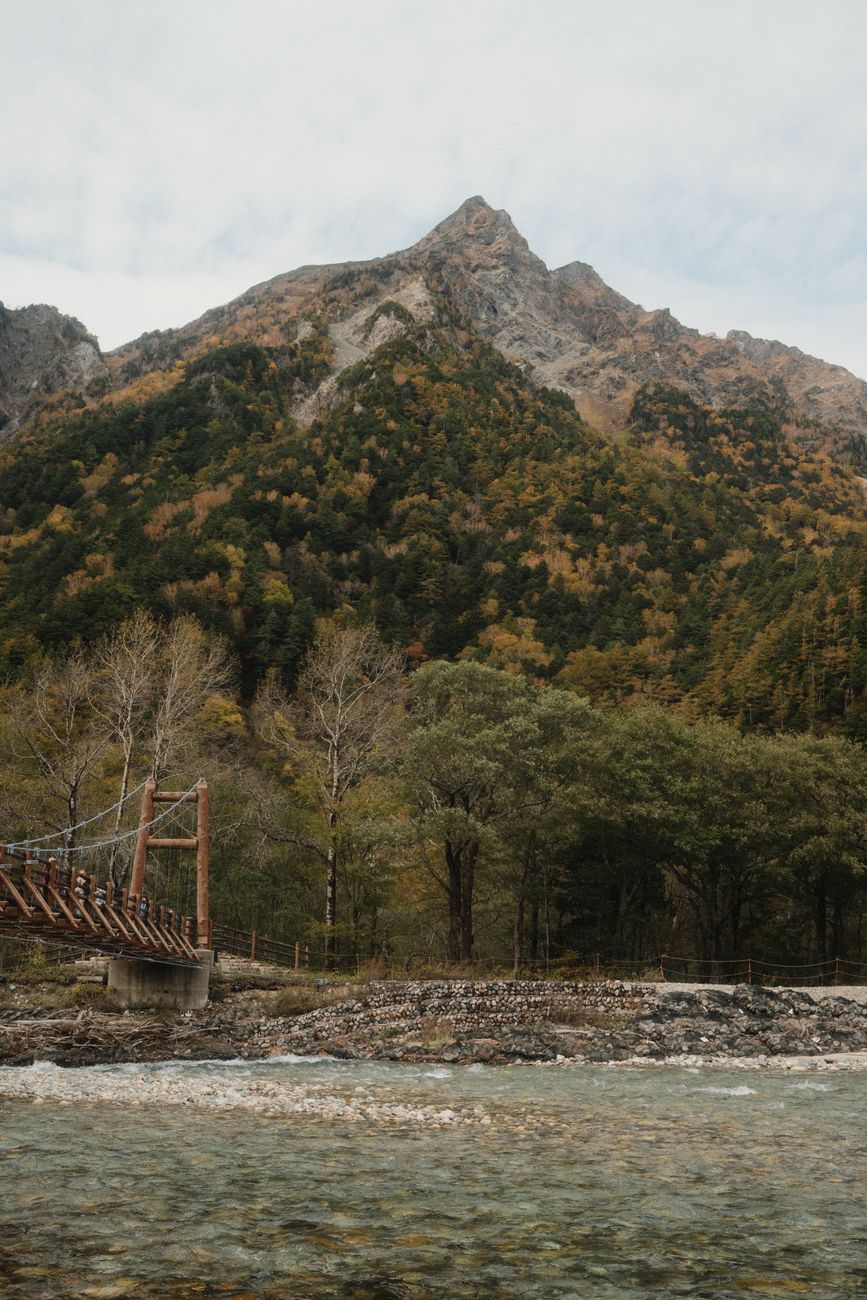 Kappa Bridge over the blue Azusa River with snow-streaked peaks behind, Kamikōchi