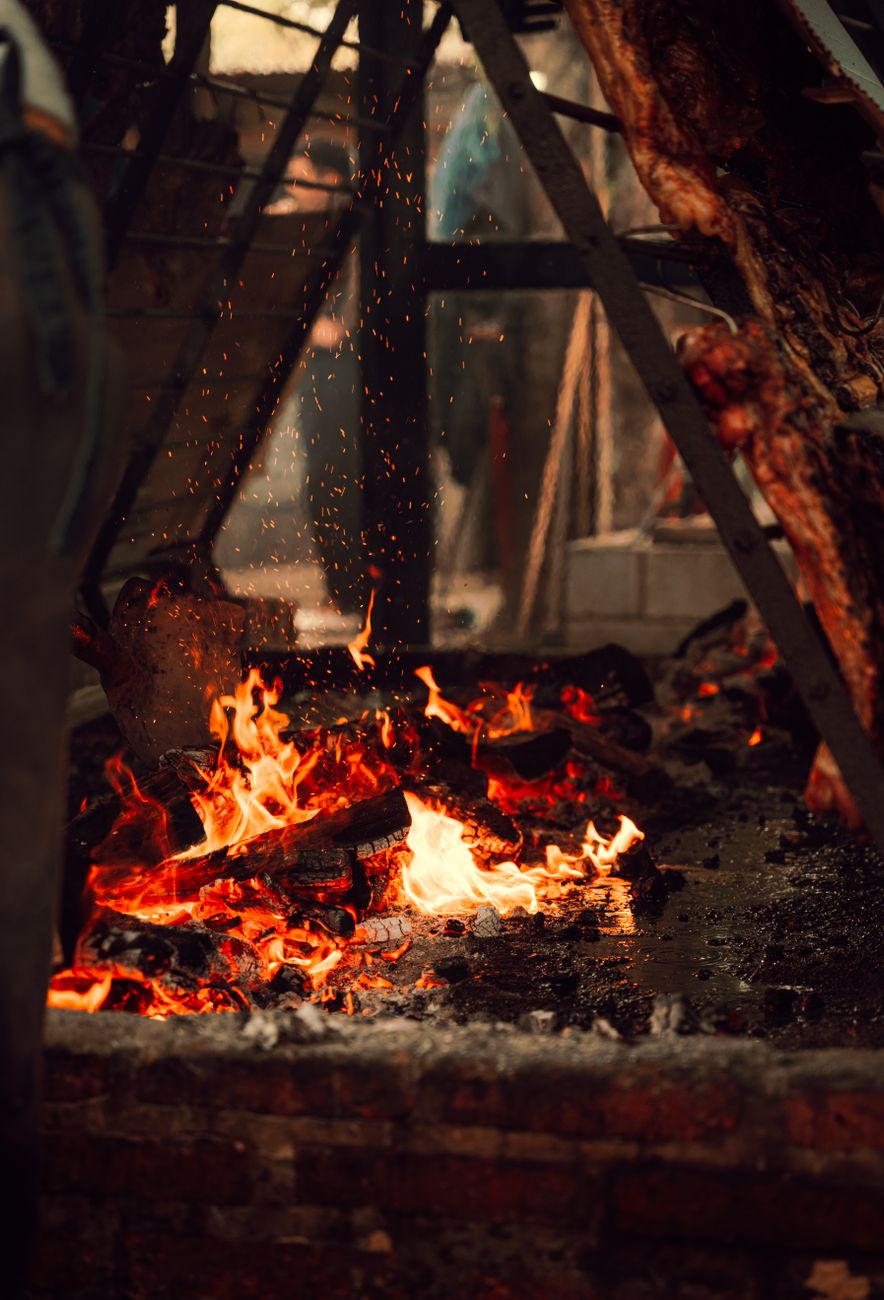 Patagonian lamb slow-roasted al palo on an iron cross over coals