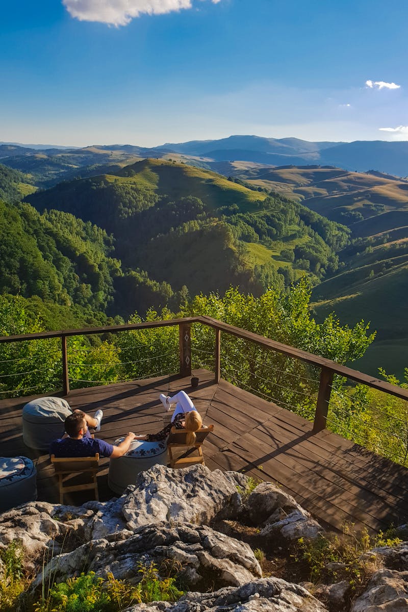 A couple on a wooden deck looking out over rolling hills