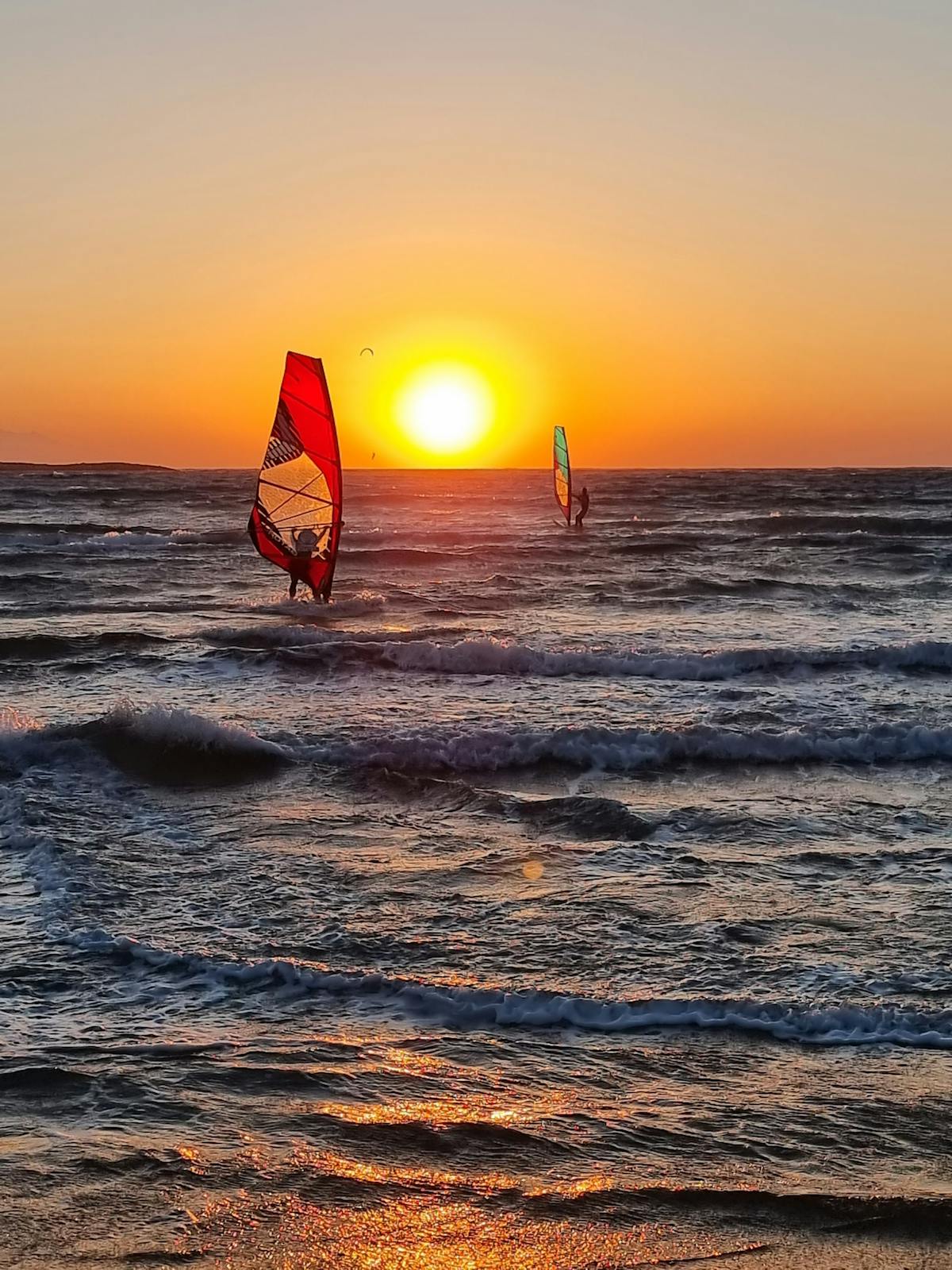 Windsurfers on the waves at sunset off Rhodes, Greece