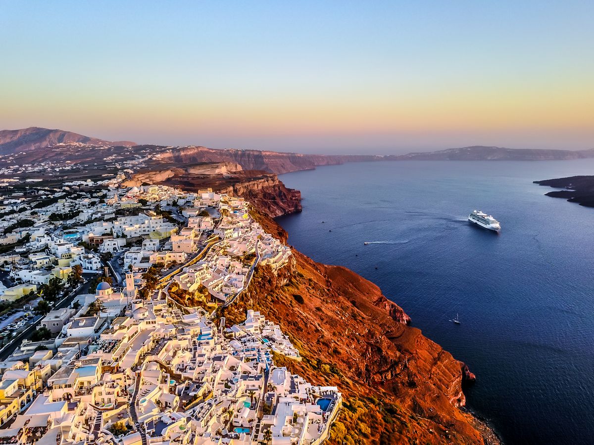 Aerial view of Santorini's whitewashed coast and the caldera at sunset