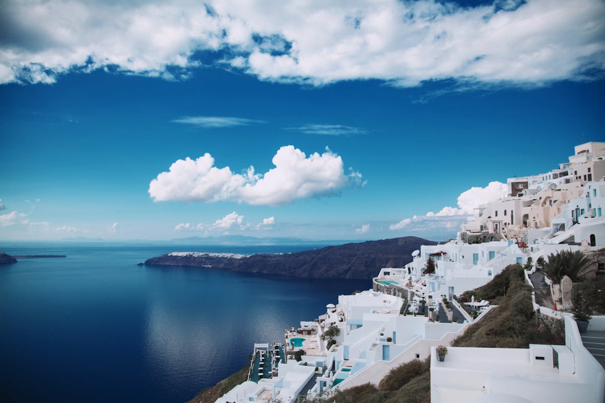 Whitewashed cliff villages of Santorini tumbling down toward the caldera and the blue Aegean