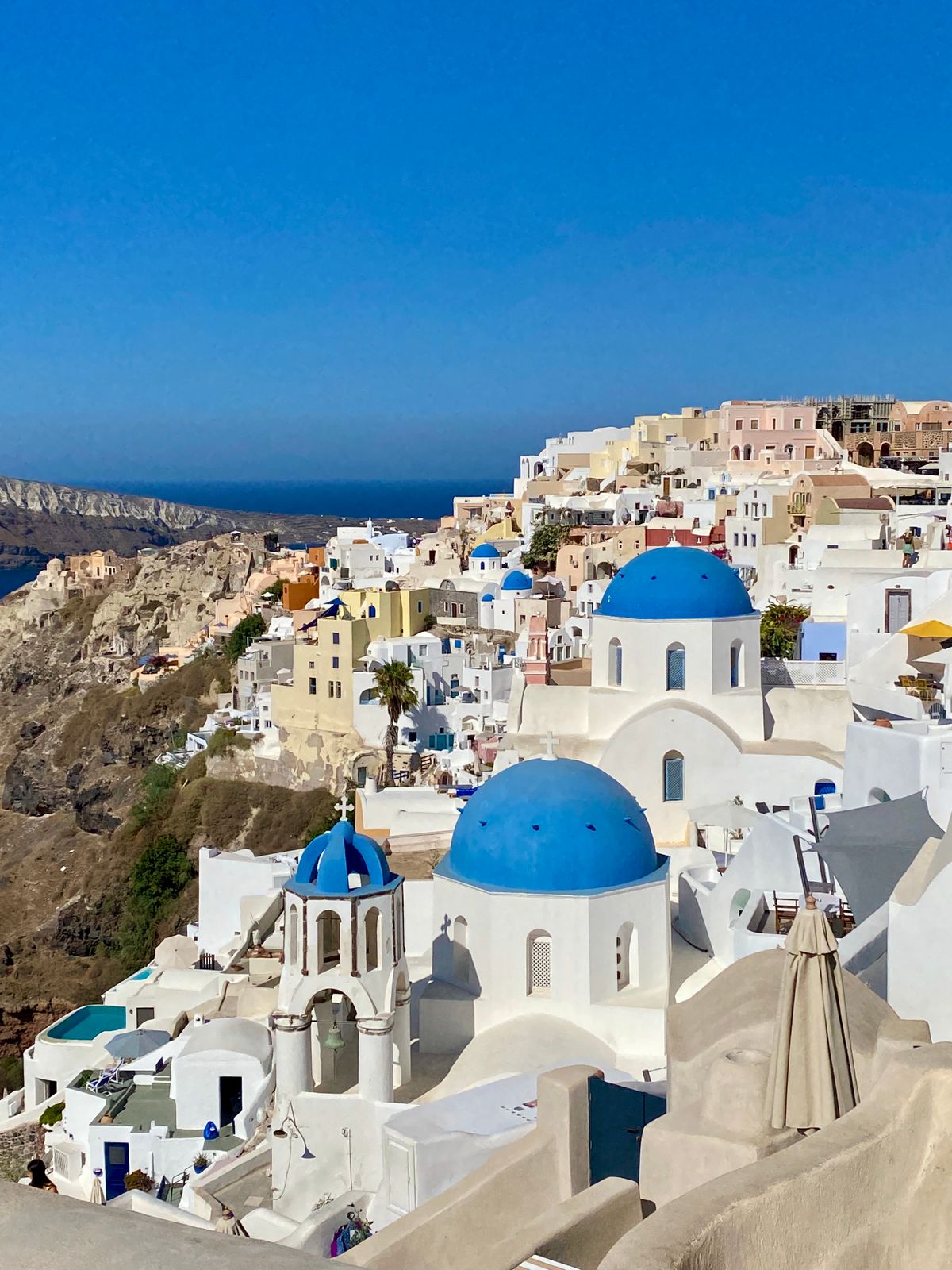 Blue-domed church and white houses above the caldera in Oia, Santorini