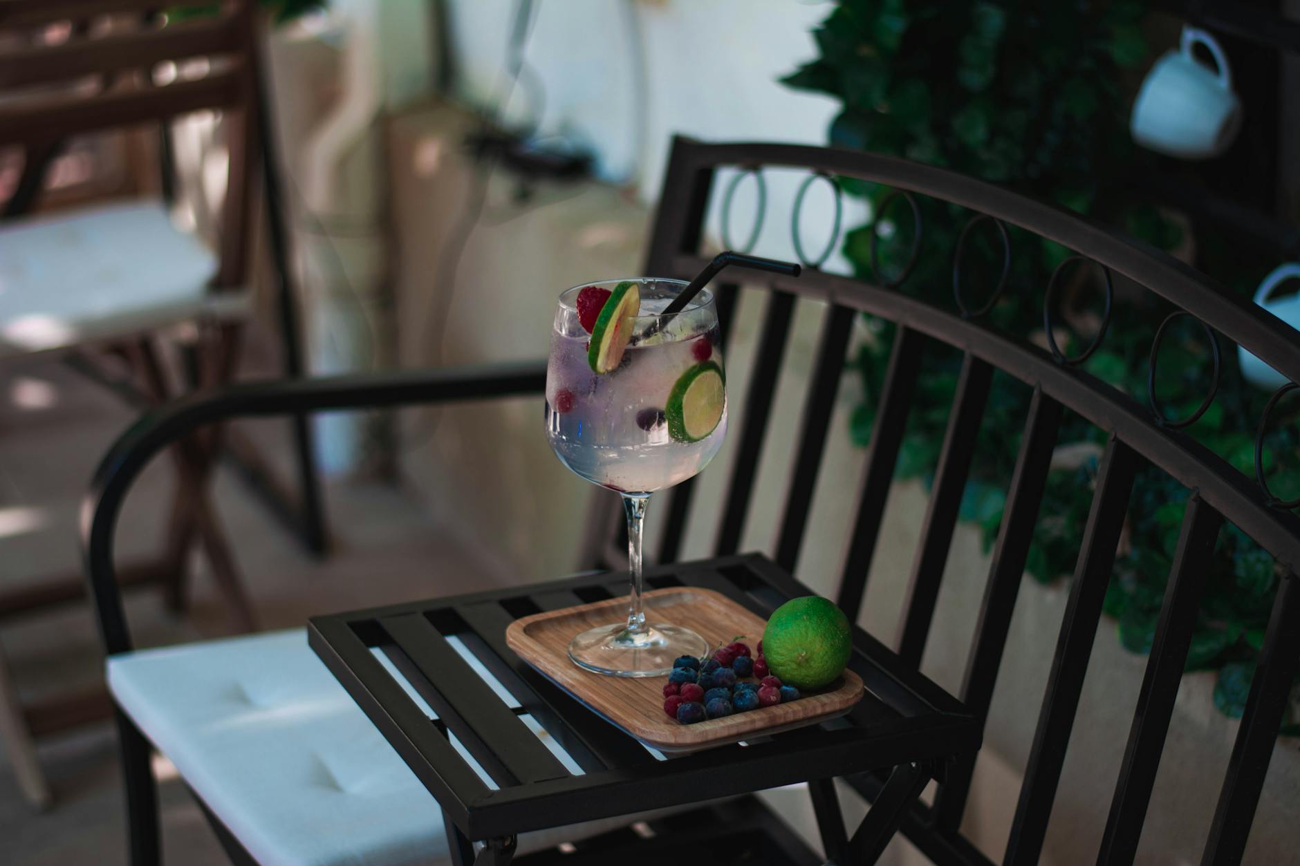 Inviting gin and tonic with lime and berries on a patio tray, perfect for summer