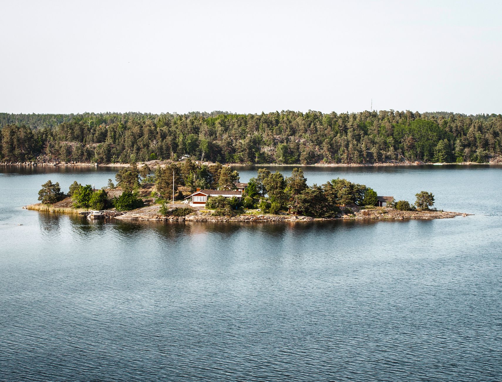 Aerial view of forested granite islands and blue water in the Stockholm archipelago