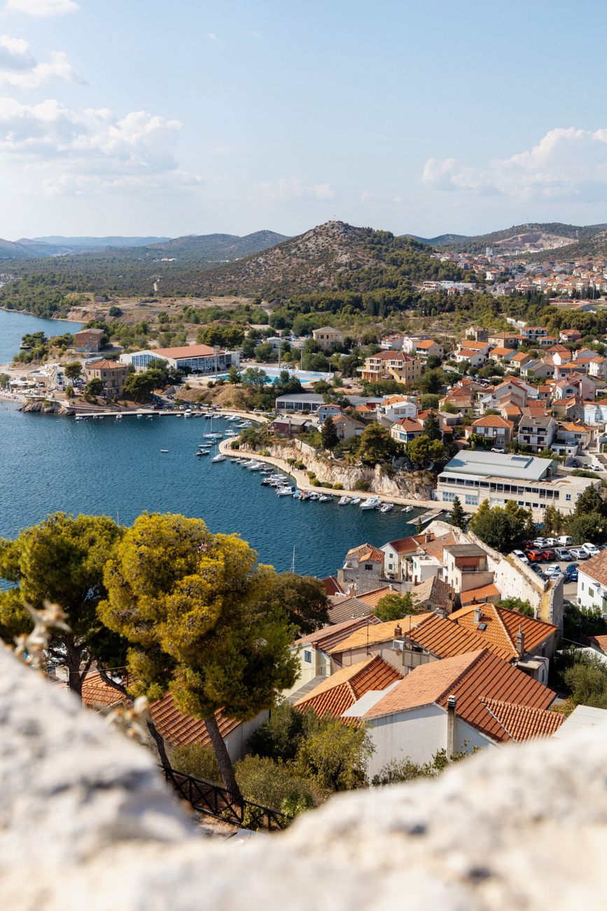 Stone houses and terracotta roofs above a harbour on the Adriatic coast